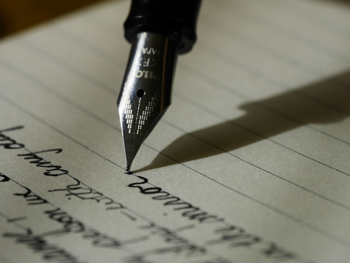 A notebook and pen on a desk, ready to write a request