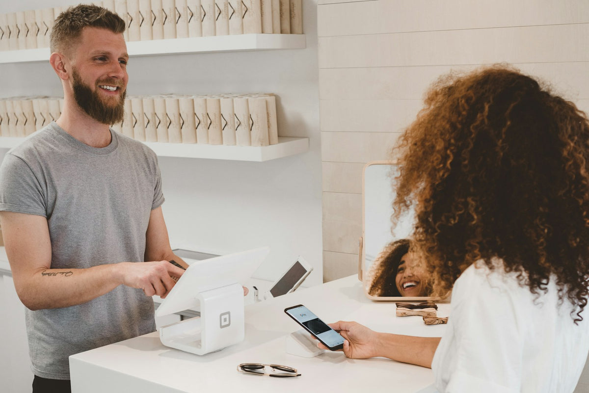 Hands holding a bank card in front of a laptop at checkout
